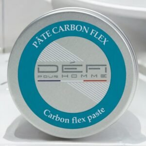 Une boîte métallique ronde avec une étiquette bleu canard sur le couvercle. L'étiquette indique « PÂTE CARBON FLEX » en haut et « Carbon flex paste » en bas. Au centre, le texte « DÉFI pour HOMME » est affiché avec un graphisme. Le fond est blanc.