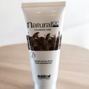 Un tube blanc de Sublimo Natural CC Color Care est posé sur une surface en bois. Le tube présente des images de fèves de cacao et l'inscription « Blond Cacao Froid, Soin Repigmentant ». Le design est épuré et minimaliste, avec une attention particulière portée aux ingrédients naturels.