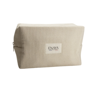 Trousse de Toilette-Enaya en coton biologique, beige et gaufré, avec une fermeture éclair latérale et une étiquette rectangulaire ENAYA sur le devant, sur fond blanc.