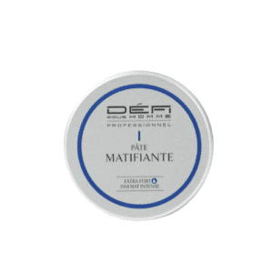 Un pot rond et blanc portant l'étiquette « Pâte Matifiante - Défi pour Homme - 75 ml » présente un texte bleu et noir entouré d'une bordure bleue, ce qui en fait le produit idéal pour ceux qui recherchent une pâte coiffante effet mat « Défi pour Homme » ou une cire effet mat pour cheveux d'homme, à la recherche d'un fini mat et tenace.