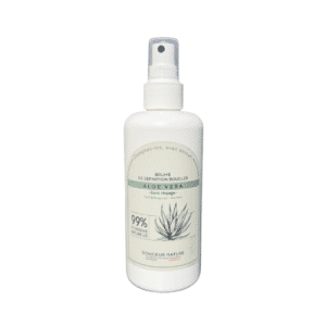 Un flacon vaporisateur blanc portant la mention « Brume de Définition Boucles Aloe Vera - 200 ml - Douceur Nature », orné de touches de vert pâle et d’une illustration d’aloès, contient une formule composée à 99 % d’ingrédients d’origine naturelle. Cette Brume de Définition Boucles Aloe Vera apporte une hydratation légère et de la définition pour des boucles douces et souples.