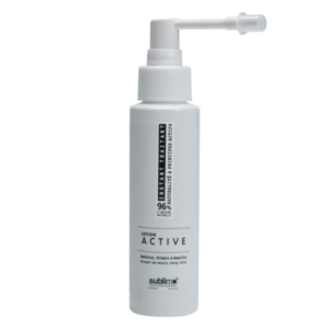 Un flacon blanc de Lotion Active INSTANT TRAIANT • SUBLIMO avec un embout spray et une étiquette noire et grise, conçu pour le soin des cheveux et du cuir chevelu.
