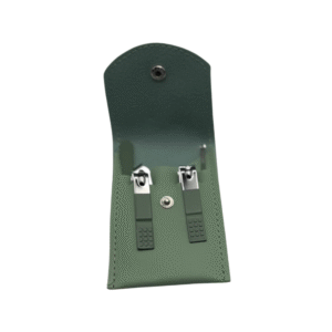 Le Set onglerie Vert amande est un étui en cuir vert avec une fermeture à bouton-pression qui permet de ranger en toute sécurité deux coupe-ongles en métal.