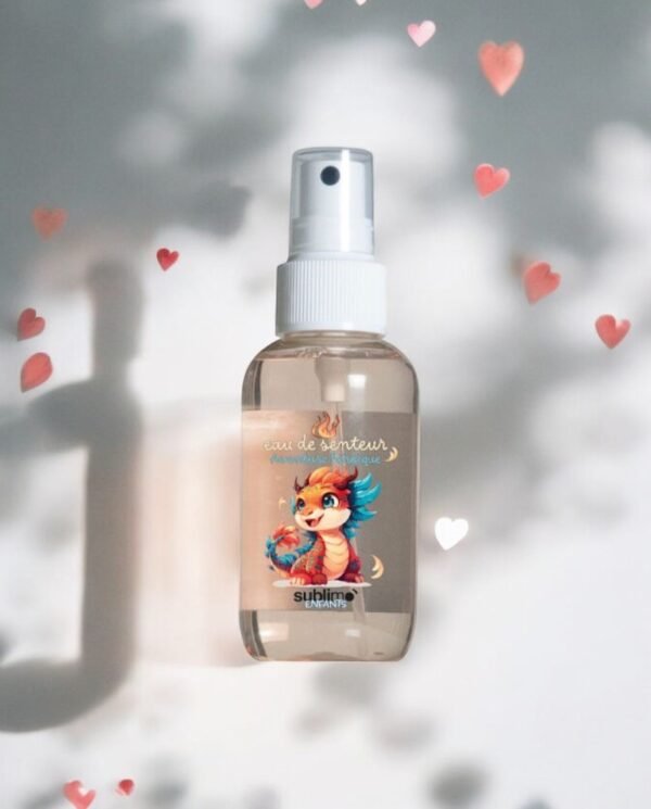 Un flacon d'Eau de Soin Dragon-Lama-Sublimo-90 ml, orné d'un dragon de dessin animé vibrant sur l'étiquette. Le flacon est orné de formes de cœurs roses délicats et doux sur un fond doux, évoquant une ambiance ludique et charmante.