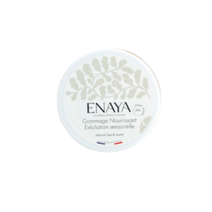 Un récipient rond blanc étiqueté « Gommage Nourrissant Exfoliant Sensorielle - Enaya - 180G », avec un motif de feuille subtil et de petits drapeaux français et africains au fond.