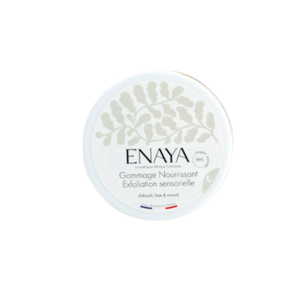 Un récipient rond blanc étiqueté « Gommage Nourrissant Exfoliant Sensorielle - Enaya - 180G », avec un motif de feuille subtil et de petits drapeaux français et africains au fond.