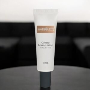 Sur un canapé noir au design épuré, un tube de crème bonne mine-Défi pour homme-30 ml étiqueté « Healthy Glow Cream » est posé sur une surface noire. Le tube est blanc avec un bouchon gris et contient 30 ml de produit.