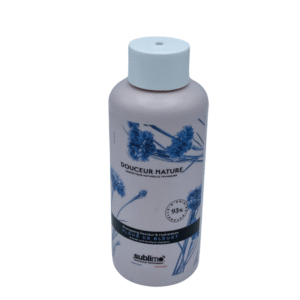 Un flacon rose de 250 ml de Shampoing Fleur de Bleuet - Sublimo - orné d'un motif de bleuet et d'un bouchon blanc. L'étiquette met en avant 93 % d'ingrédients naturels pour un shampoing naturel doux, hydratant et adoucissant.