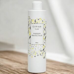 Flacon blanc de shampoing protecteur pur EYRLAN, 300 ml. Le flacon présente un design minimaliste avec de délicats motifs abstraits jaunes et gris entourant l'étiquette. Il est posé sur une surface en bois avec un fond blanc flou.