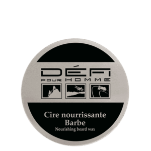 Une boîte ronde étiquetée « Cire nourrissante barbe - Défi pour Homme - 75 ml » présente trois icônes et la phrase « Cire à barbe nourrissante » sur un design noir et argent élégant.