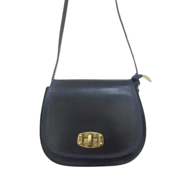 Le Sac à bandoulière en cuir rigide est un petit sac en cuir bleu foncé, doté d'une longue lanière et d'un fermoir à boucle tournante en métal doré sur le rabat avant, sur fond blanc.