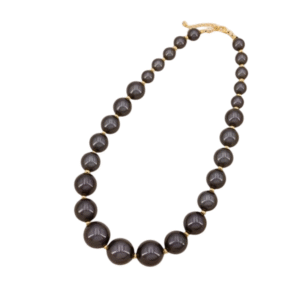Le Collier billes acryliques colorées /Gris foncé présente des perles acryliques rondes et brillantes de couleur gris foncé, dont la taille augmente vers le centre. Il se termine par un fermoir doré et se présente élégamment sur un fond blanc.