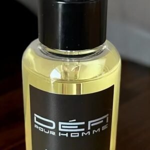 Un flacon de 50 ml d'huile à barbe, étiqueté « Huile de barbe parfumée-Vanille Ambrée- Défi Pour homme », avec un bouchon compte-gouttes repose sur une surface en bois, promettant un mélange séduisant pour votre routine de soins.