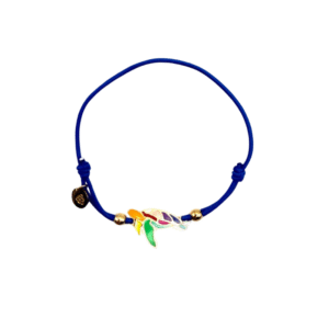 Le Bracelet acier inoxydable laqué Tortue/Marine est un bracelet en cordon bleu avec une breloque tortue en acier inoxydable émaillé, deux petites perles dorées et une étiquette ronde noire près du nœud, sur fond blanc.