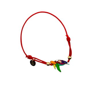 Le Bracelet acier inoxydable laqué Tortue/Rouge est un bracelet en cordon rouge avec une breloque tortue colorée, deux perles dorées et une petite étiquette ronde noire, sur fond blanc.