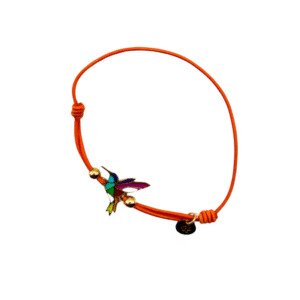 Un bracelet en cordon orange avec une breloque colibri en acier inoxydable laqué argent colibri/Orange, des perles dorées et une petite étiquette ronde noire, sur fond blanc.