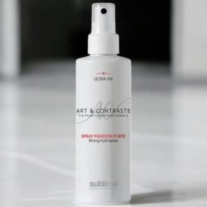 Une bouteille blanche de laque coiffante est posée à la verticale sur une surface lisse. L'étiquette indique « Art & Contraste Ultra Fix Spray Fixation Forte Strong Hold Spray ». Elle est dotée d'un embout de pulvérisation et d'un design minimaliste. L'arrière-plan est légèrement flouté.