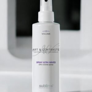 Un flacon pulvérisateur blanc étiqueté « Art & Contraste Coiffeurs Professionnels » avec les textes « Spray Ultra Waves » et « Volume 2+ » est posé sur une surface réfléchissante. La marque « sublimo » est imprimée en bas. Un arrière-plan flou ajoute de la profondeur.