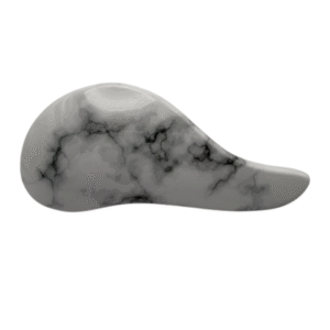 La Brosse Méli-Mélo Marbrée présente une forme lisse et incurvée avec un motif de marbre gris et des veines noires, ressemblant à une pierre ergonomique, représentée sur un fond blanc.