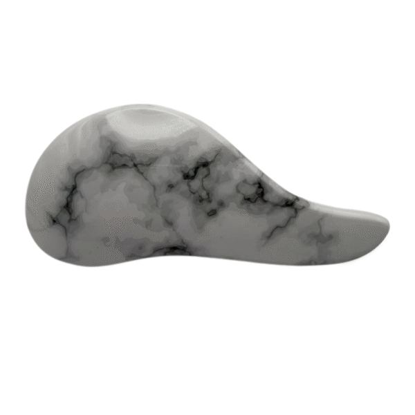 La Brosse Méli-Mélo Marbrée présente une forme lisse et incurvée avec un motif de marbre gris et des veines noires, ressemblant à une pierre ergonomique, représentée sur un fond blanc.