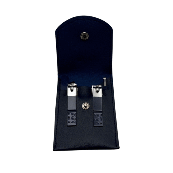 Un étui en cuir noir avec bouton-pression en métal contient deux coupe-ongles argentés, chacun d'une taille différente avec des poignées texturées, à l'intérieur d'une doublure sombre. Cette trousse compacte est aussi pratique que le Set onglerie Bleu marine.