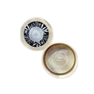 Deux contenants ronds de couleur crème, l'un étiqueté « Body Soufflé » avec un couvercle à motifs de feuilles noires et blanches, l'autre ouvert, sont exposés à côté du Savon Noyau d'Abricot et Chaï - 120g-Saly Cosmétiques sur un fond blanc.