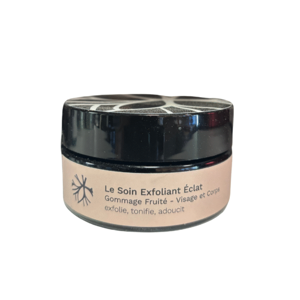 Un petit pot rond étiqueté "Soin exfoliant éclat 100ml - Saly Cosmétiques" pour le visage et le corps est doté d'un couvercle noir et d'une étiquette beige.