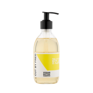 Flacon pompe transparent de Shampooing Détox -Vegan-290ml de Cut by Fred avec une étiquette jaune et blanche comportant du texte noir, présenté isolé sur fond blanc.