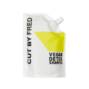 Pochette de recharge blanche avec inscription « Recharge Shampooing Détox - Vegan - 520 ml - Cut by Fred » en noir, avec un motif géométrique jaune et un bec verseur en haut à droite. Idéale pour des soins capillaires purs, vegan et purifiants.