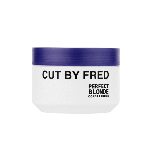 Un pot blanc avec un couvercle bleu foncé étiqueté « Après Shampooing Déjaunisseur-Perfect blonde-400ml-Cut by Fred » se trouve sur un fond blanc uni.