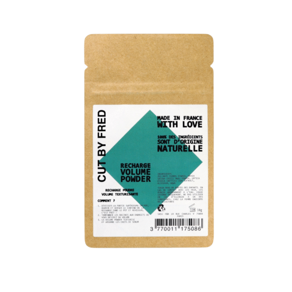 Une pochette marron étiquetée « CUT BY FRED » contient le shampooing sec Recharge Poudre Volume Vegan (10 g). L'emballage, orné de motifs géométriques verts et d'un texte bilingue noir, met en avant les ingrédients naturels et indique qu'il est fabriqué en France.