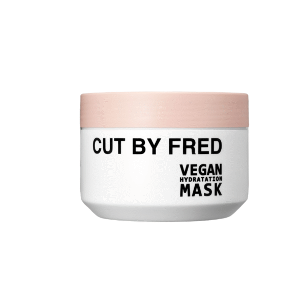 Le masque hydratant végétalien 400 ml de Cut by Fred est présenté dans un pot blanc avec un couvercle rose clair et un étiquetage noir audacieux, idéal pour vos besoins d'hydratation capillaire végétaliens.