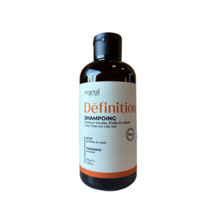 Le flacon marron de Shampoing Définition – Cheveux Bouclés – 200 ml, au bouchon noir, est conçu pour les cheveux bouclés et frisés. Il est orné d'une étiquette blanche avec un texte orange et vert. Ce soin lavant est idéal pour définir les boucles.