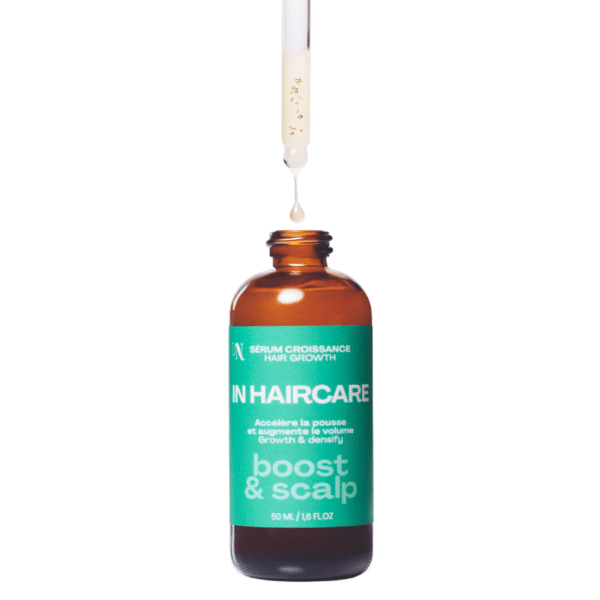Un flacon en verre brun ouvert de 50 ml de Sérum Boost & Scalp - In Hair Care avec une étiquette verte est présenté comme un compte-gouttes distribuant un liquide beige - un complément anti-chute de cheveux naturel idéal pour votre routine.