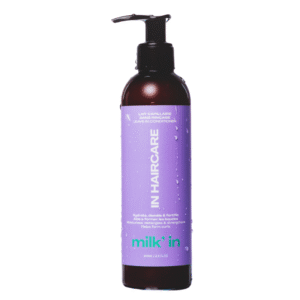 Un grand après-shampoing sans rinçage Milk’ In-définit les boucles, hydrate et fortifie de 250 ml de In Hair Care avec une pompe noire et une étiquette violette avec un texte blanc, présenté sur un fond blanc.
