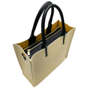 Le Sac bandoulière en cuir véritable-Beige est un sac en cuir beige avec des poignées et des garnitures noires, des ferrures dorées, une poche intérieure zippée noire et une doublure jaune pour un look élégant et chic.