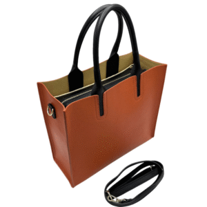 Le Sac bandoulière en cuir véritable-Orange est un fourre-tout structuré en cuir orange avec des poignées noires, une bandoulière noire amovible, une pochette intérieure zippée, une doublure beige et des ferrures argentées pour une finition élégante.