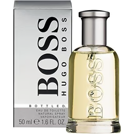 Un flacon de 50 ml d'Eau de Toilette Hugo Boss Bottled avec un liquide jaune clair se trouve devant sa boîte gris argenté, à côté d'un Goldwell Dualsenses Just Smooth Masque capillaire lissant 200 ml, ajoutant une touche raffinée de style et de soin des cheveux.